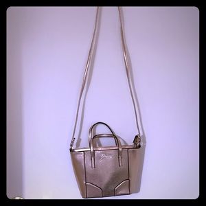 A rose gold Guess cross body bag